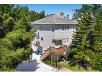 Two-story home with mature trees and multiple wooden decks and stairs at 2003 12Th W Ave, Bradenton, FL 34205