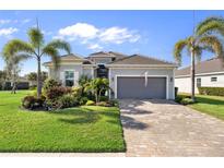 Charming single-story home featuring lush landscaping, brick driveway, and attached two car garage at 25325 Longmeadow Dr, Punta Gorda, FL 33955