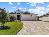Charming single-story home featuring a three-car garage and a beautifully landscaped front yard with a paver driveway at 3617 Wild Blossom Pl, Parrish, FL 34219