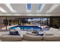 Bright living room with skylights, pool views, waterway, and comfortable white sofas at 500 Halyard Ln, Longboat Key, FL 34228