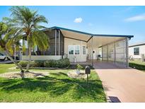 Charming single-story home with a covered carport, screened porch, and well-maintained landscaping at 709 Riverview Cir, North Port, FL 34287