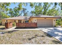 Charming one-story home featuring a two-car garage, wood fence, and a well-maintained lawn at 8036 Conservatory Cir, Sarasota, FL 34243