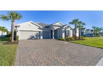 Charming single-story home with a three-car garage, beautiful landscaping, and a brick driveway at 12307 Blue Hill Trl, Bradenton, FL 34211