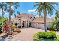 Elegant Mediterranean-style home featuring a tile roof, paver driveway, and lush tropical landscaping at 13708 Red Rock Pl, Lakewood Ranch, FL 34202