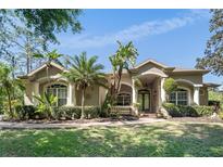 Beautiful single-story home featuring lush landscaping, a well-manicured lawn, and an inviting entryway at 13955 Pine Woods E Ln, Sarasota, FL 34240