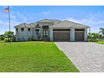 Beautiful single-story home with three-car garage, manicured lawn, and brick paved driveway at 16768 San Edmundo Rd, Punta Gorda, FL 33955