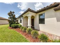 Inviting front entrance with manicured landscaping and decorative columns under a clear sky at 19993 Benissimo Dr, Venice, FL 34293