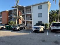 A multi-story condominium with parking spaces and stairwell in a well-lit area, showcasing its exterior at 2330 Canal Dr # G27, Bradenton, FL 34207