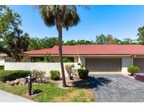Charming single-story home with a red tile roof, lush landscaping, and an attached two-car garage at 3804 Sun Eagle Ln, Bradenton, FL 34210