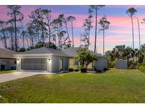 Charming single-story home with a well-maintained lawn and a screened garage, all under a beautiful sunset sky at 3865 N Cranberry Blvd, North Port, FL 34286