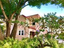 Charming two-story home featuring stucco walls, a red tile roof, and lush tropical landscaping at 401 27Th W St, Bradenton, FL 34205