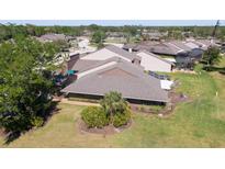 A scenic aerial view of a well-maintained home featuring an outdoor patio and lush green landscaping at 5604 Doral Dr, Sarasota, FL 34243