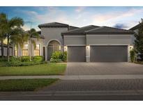 Charming single-story home with a tile roof, arched entry, three-car garage and well-manicured landscaping at 8016 Grande Shores Dr, Sarasota, FL 34240