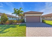 Charming single-story home with a well-manicured lawn, paver driveway, and a two-car garage, perfect for suburban living at 10230 Highland Park Pl, Palmetto, FL 34221
