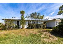 Charming single-story home featuring a well-maintained lawn and mature landscaping at 18422 Burkholder Cir, Port Charlotte, FL 33948