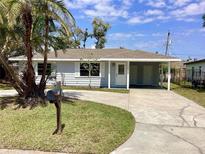 Charming single-story home with a well-maintained lawn, driveway, and a carport at 2885 Poplar St, Sarasota, FL 34237