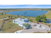Stunning lakefront home with lush landscaping, circular driveway, and beautiful water views at 29527 Leah Rd, Punta Gorda, FL 33982