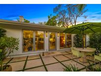 Outdoor patio with tiled flooring, dining set, and lush greenery for serene relaxation at 494 Sapphire Dr, Sarasota, FL 34234