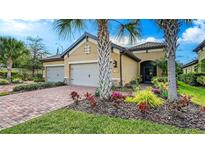 Charming single-story home with a well-manicured lawn, brick driveway, and beautiful landscaping at 6492 Positano Ct, Sarasota, FL 34243