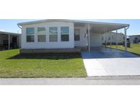 Charming single-story home featuring a covered parking area, well-maintained lawn, and traditional architecture at 705 Blackburn Blvd, North Port, FL 34287