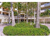 Condominium building exterior featuring lush tropical landscaping and architecture at 2020 Harbourside Dr # 454, Longboat Key, FL 34228