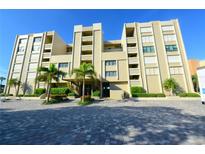 Beautiful condominium building with palm trees and brick-paved parking at 2675 Gulf Of Mexico Dr # 403, Longboat Key, FL 34228