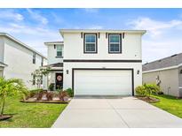 Charming two-story home featuring a clean white exterior and well-manicured lawn, plus a two car garage at 3027 Great Abaco Way, Bradenton, FL 34208