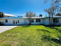 Single story home with blue tarp on roof, front lawn and parking at 305 59Th St, Holmes Beach, FL 34217