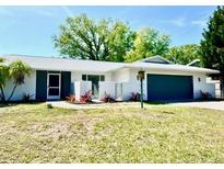 Charming single-story home with a well-maintained lawn and a dark-blue two-car garage at 3320 Riviera Dr, Sarasota, FL 34232