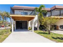 Charming home exterior featuring a covered parking area and a balcony on the second floor at 3333 Ramblewood Pl, Sarasota, FL 34237