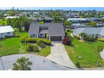 An aerial view showcases a well-maintained single-Gathering home with lush landscaping and a long driveway at 4704 Coral Lake Dr, Bradenton, FL 34210