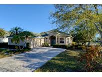 Charming single story home featuring a paved driveway, two-car garage and lush landscaping at 6619 Copper Ridge Trl, Bradenton, FL 34201