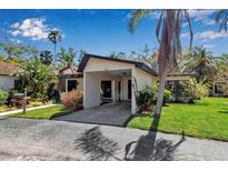 Charming single-story home with a covered parking area and lush tropical landscaping at 6946 Woodwind Dr # 2, Sarasota, FL 34231