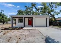 Charming single-story home boasts a bright red front door and an attached one car garage at 732 15Th E St, Bradenton, FL 34208