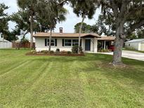 Charming single-story home with lush lawn and mature trees, inviting curb appeal at 775 Liberty St, Englewood, FL 34223