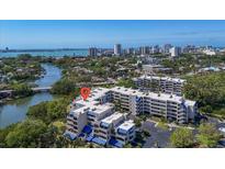 Aerial view of a condo complex with blue awnings, lush greenery, and waterfront views at 835 S Osprey Ave # 415, Sarasota, FL 34236
