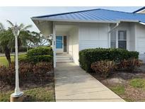 Charming home with a blue metal roof and landscaped front yard. Light post at the front walk at 859 Audubon Dr # 859, Bradenton, FL 34209