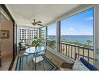 Bright lanai featuring a ceiling fan, tile flooring, an area rug, and floor to ceiling windows with water views at 8735 Midnight Pass Rd # 306B, Sarasota, FL 34242