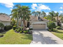 Charming single-story home with a well-manicured lawn, mature palms, and a brick driveway at 11716 Strandhill Ct, Lakewood Ranch, FL 34202