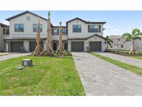 Inviting townhome boasts a well-manicured lawn, long driveway, and an attached garage at 14783 Lyla Ter, Bradenton, FL 34211