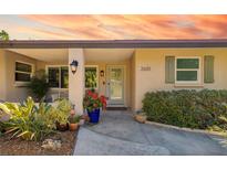 Inviting front entrance with decorative plants, stylish sconces, and light green trim at 2610 Jefferson Cir, Sarasota, FL 34239