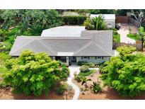 Charming home with a well-manicured front yard, lush landscaping, and a welcoming walkway leading to the entrance at 2610 Jefferson Cir, Sarasota, FL 34239