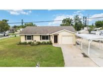 Charming single story home with a tan exterior, well-maintained lawn, and a carport for covered parking at 4221 3Rd W Ave, Palmetto, FL 34221
