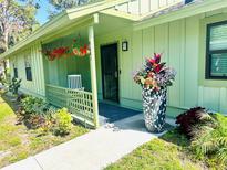Charming home entrance with a cozy porch, decorative plants, and a well-maintained walkway at 5061 Barrington Cir # 1302, Sarasota, FL 34234