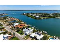 Aerial view of a waterfront property with lush landscaping, a private dock, a boat lift, and stunning water views at 527 Key Royale Dr, Holmes Beach, FL 34217