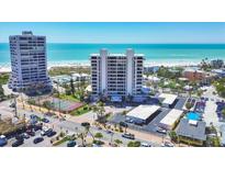 Stunning aerial view of the condo building, beach, and tennis courts on a sunny day at 5300 Ocean Blvd # 202, Sarasota, FL 34242