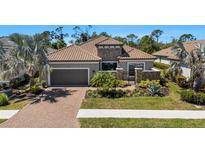 Charming single-story home with a brick driveway, neutral colors, stone accents, and manicured landscaping at 5329 Trails Bend Ct, Sarasota, FL 34238