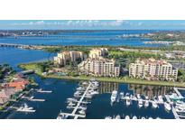 Panoramic aerial view of waterfront condo community with private marina, lush landscaping, and coastal access at 611 Riviera Dunes Way # 107, Palmetto, FL 34221