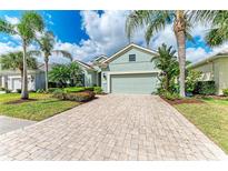 Charming single-story home featuring a brick driveway, lush landscaping, and a two-car garage at 7278 Lismore Ct, Lakewood Ranch, FL 34202