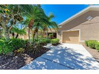 Charming single-story home featuring a beige facade, well-manicured landscaping, and a two-car garage at 9121 Stone Harbour Loop, Bradenton, FL 34212